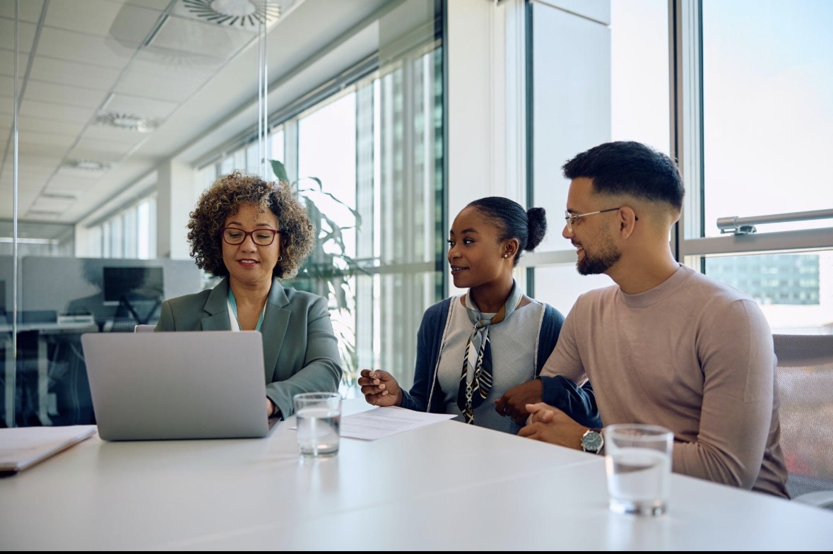 Advisers meeting with clients around a table to review documents